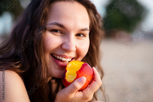 Canvas Print Girl eats juicy peach on the beach. Ripe peach.