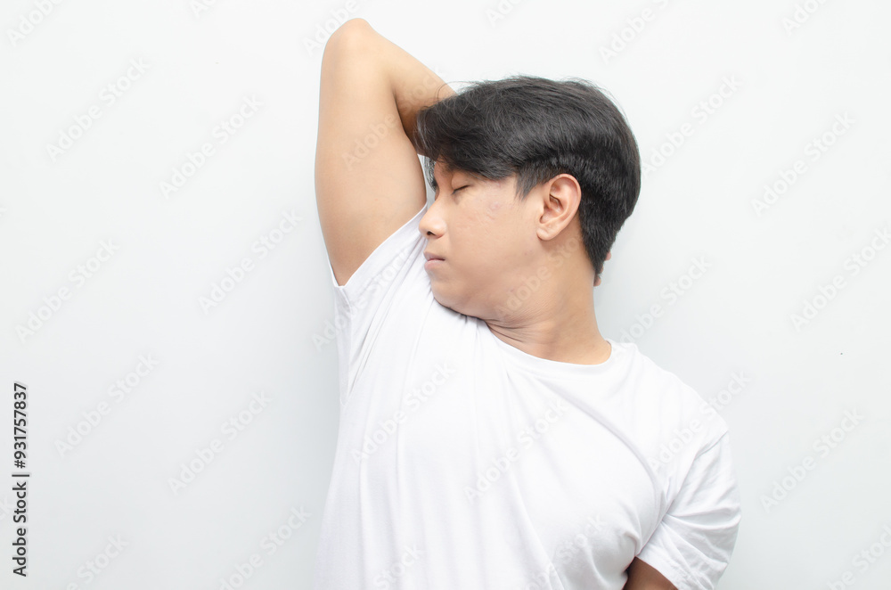 A young Asian man in white tshirt smells the freshness of his odor from armpit. Man enjoys his freshness and cleanliness. man smelling his armpit A young Asian man in white tshirt smells the freshness of his odor from armpit. Man enjoys his freshness and cleanliness. man smelling his armpit