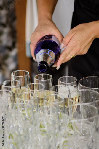 Waiter pours champagne into the glasses