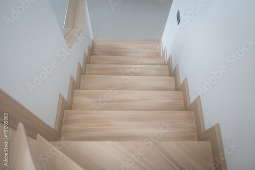  A modern, light-toned wooden staircase inside a contemporary home