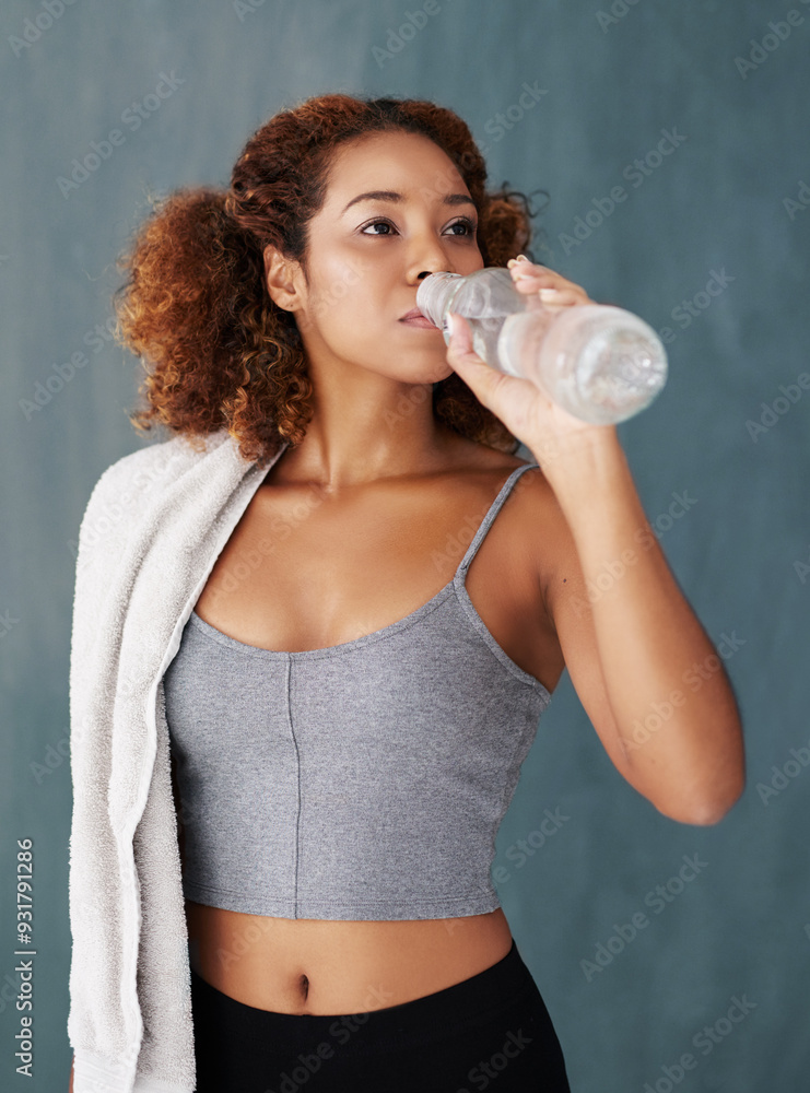 Woman, thirsty and drinking water in studio after workout, daily exercise and fitness break for wellness. Female model, hydration and nutrition with h2o bottle for mineral, detox and gray background Woman, thirsty and drinking water in studio after workout, daily exercise and fitness break for wellness. Female model, hydration and nutrition with h2o bottle for mineral, detox and gray background