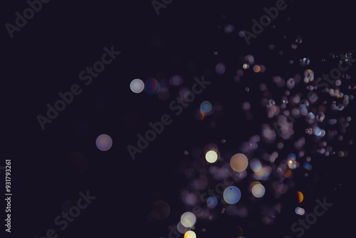 Abstract bokeh lights with colorful circles on dark background, creating a dreamy and festive atmosphere