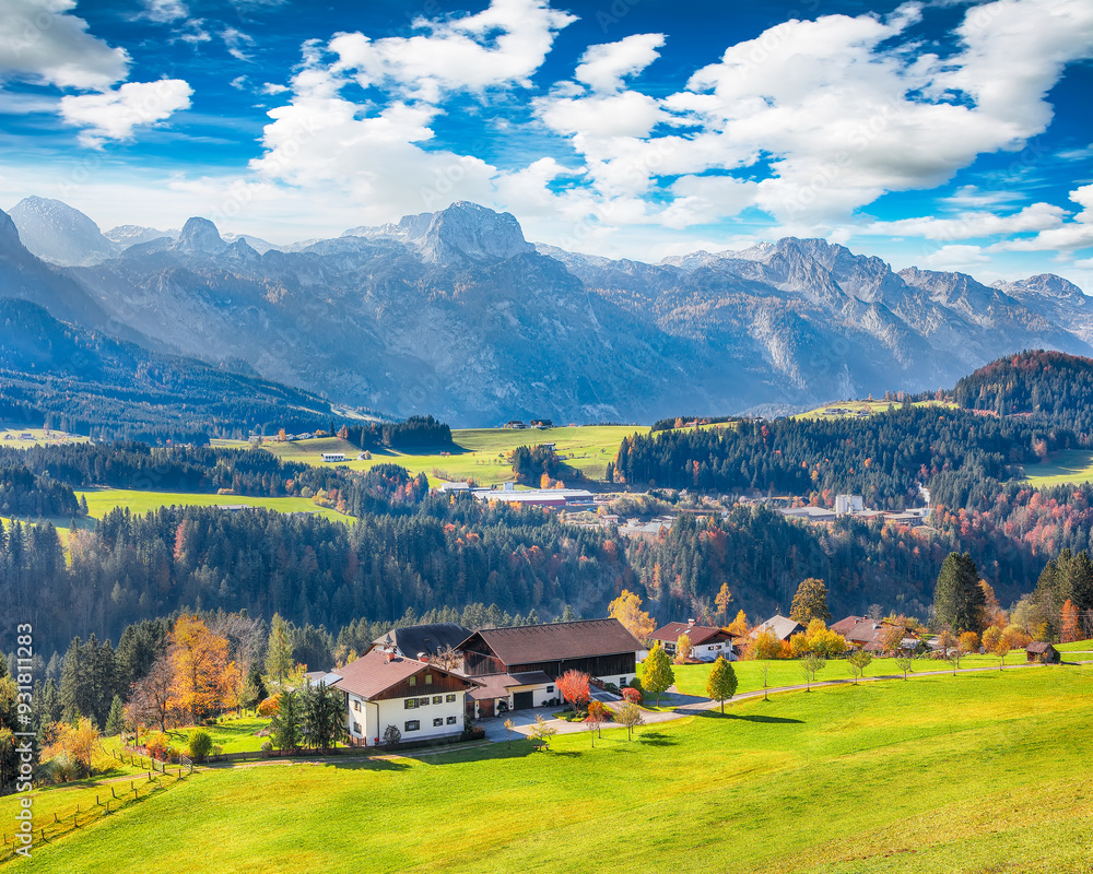Breathtaking view of Alpine green fields and traditional wooden houses near Abtenau village at autumn sunny day.