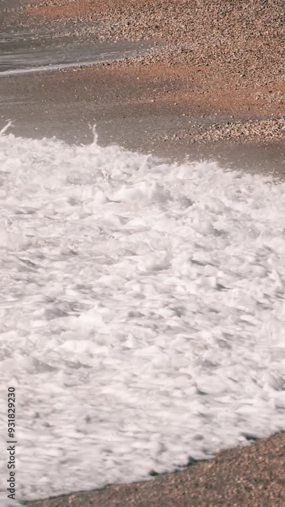 Sea waves crashing on the sand beach, telephoto lens slow motion shot, vertical video Sea waves crashing on the sand beach, telephoto lens slow motion shot, vertical video