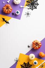 Vibrant Halloween vertical flat lay featuring pumpkins, spider webs, bats, and spooky eyeball decorations in a colorful arrangement