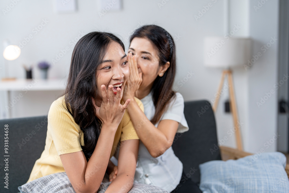 Two women are sitting on a couch, one of them is making a face Two women are sitting on a couch, one of them is making a face