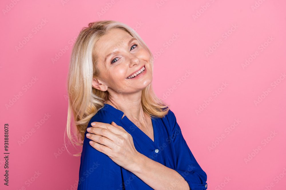 Photo portrait of lovely pensioner lady hug self touch shoulder dressed stylish blue garment isolated on pink color background Photo portrait of lovely pensioner lady hug self touch shoulder dressed stylish blue garment isolated on pink color background