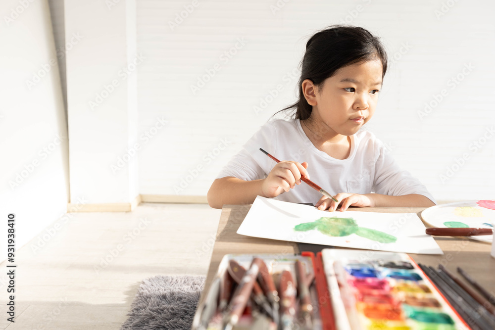 Child girl drawing and filled with colorful paints on paper in the classroom Child girl drawing and filled with colorful paints on paper in the classroom