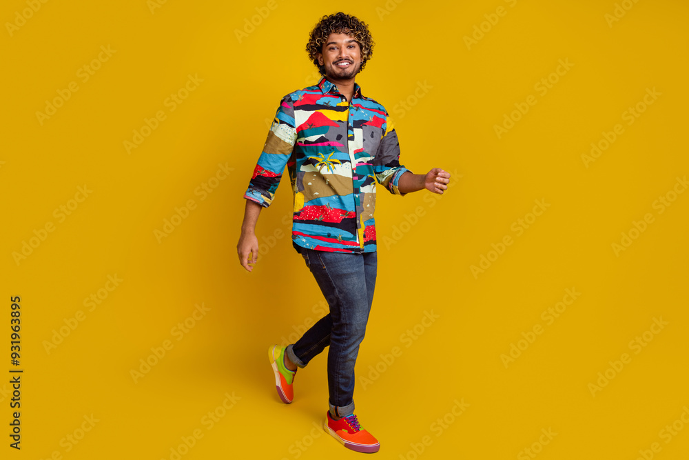 Full length photo of handsome young male walking shopping dressed stylish colorful garment isolated on yellow color background Full length photo of handsome young male walking shopping dressed stylish colorful garment isolated on yellow color background