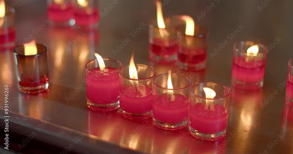 Red candle lit to ask for blessings from monks.Candles in glasses.Red candle in glass. Red candle lit to ask for blessings from monks.Candles in glasses.Red candle in glass.