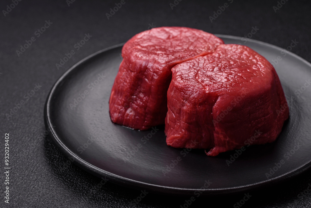 Fresh juicy raw beef medallions with salt and spices Fresh juicy raw beef medallions with salt and spices