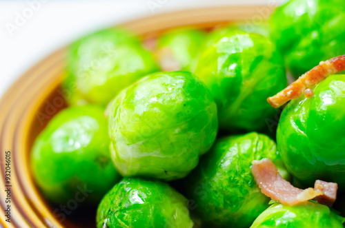 A plate of green brussels sprouts with bacon on top photo