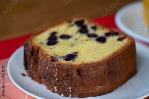 A piece of cake with currants on a plate.