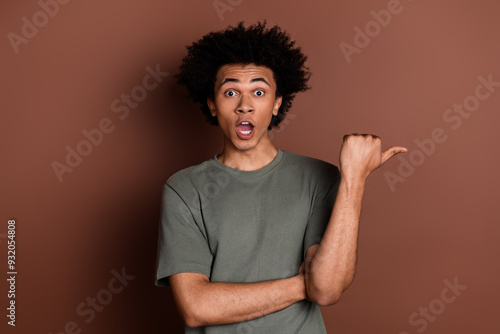 Photo portrait of handsome young male point amazed empty space dressed stylish khaki garment isolated on brown color background