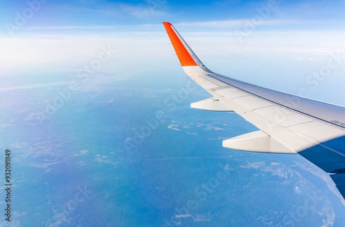 Aerial view from airplane window above green ground. View from the airplane window with beautiful clouds at sunrise