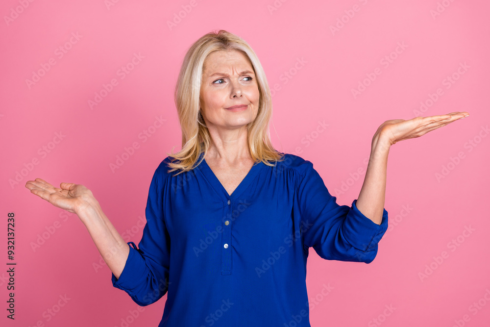 Obraz premium Photo portrait of lovely pensioner lady compare skeptical empty space dressed stylish blue garment isolated on pink color background