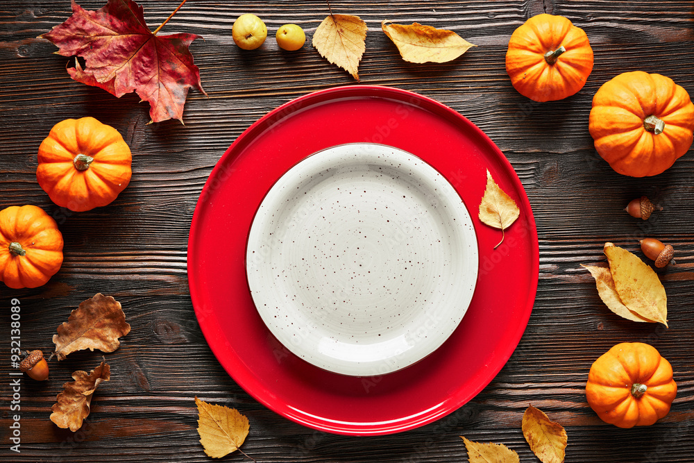 Empty red and white plates on dark wooden background in autumn decor. Top view. Empty red and white plates on dark wooden background in autumn decor. Top view.