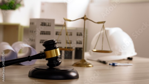 Design and build a new residential building - Real estate concept. judge gavel on building blueprint plans with a safety helmet and building model. Paper sheet with pen on wooden table.