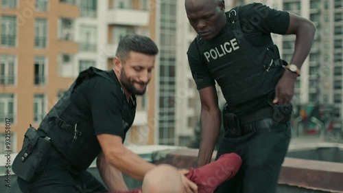 Policemen Arresting a bald criminal in the city