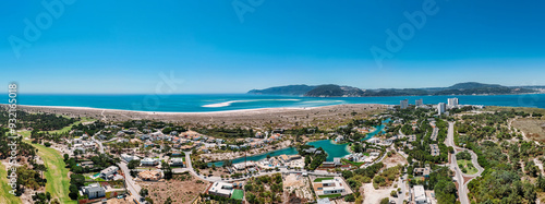 Aerial drone panoramic view of Troia, a peninsula located in Grandola Municipality, next to Sado River estuary, with Arrabida mountain range on left, Alentejo, Portugal