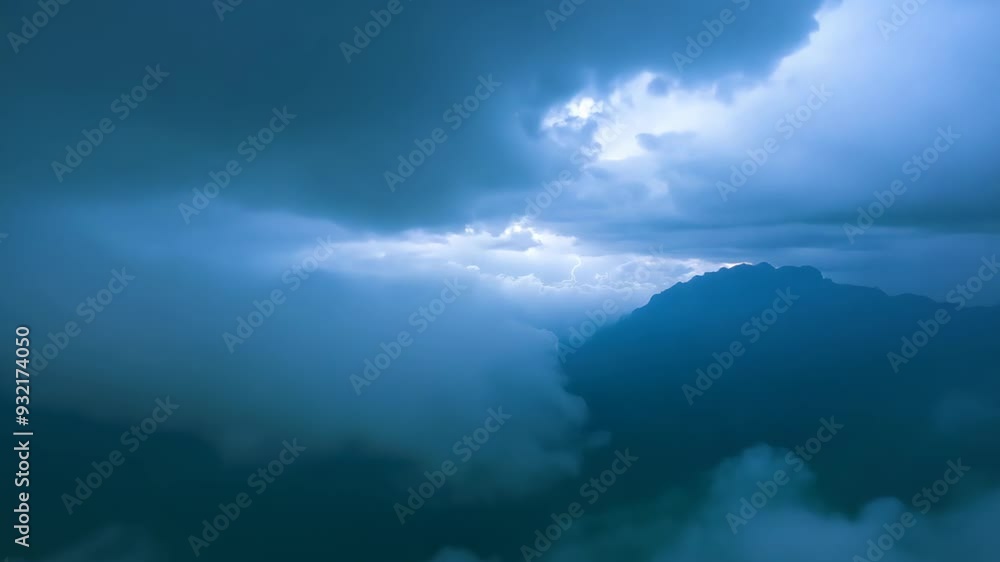 The drone flies through thick clouds, with mountain peaks visible in the background The drone flies through thick clouds, with mountain peaks visible in the background