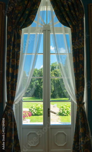 A window with beautiful curtains overlooking an ancient park