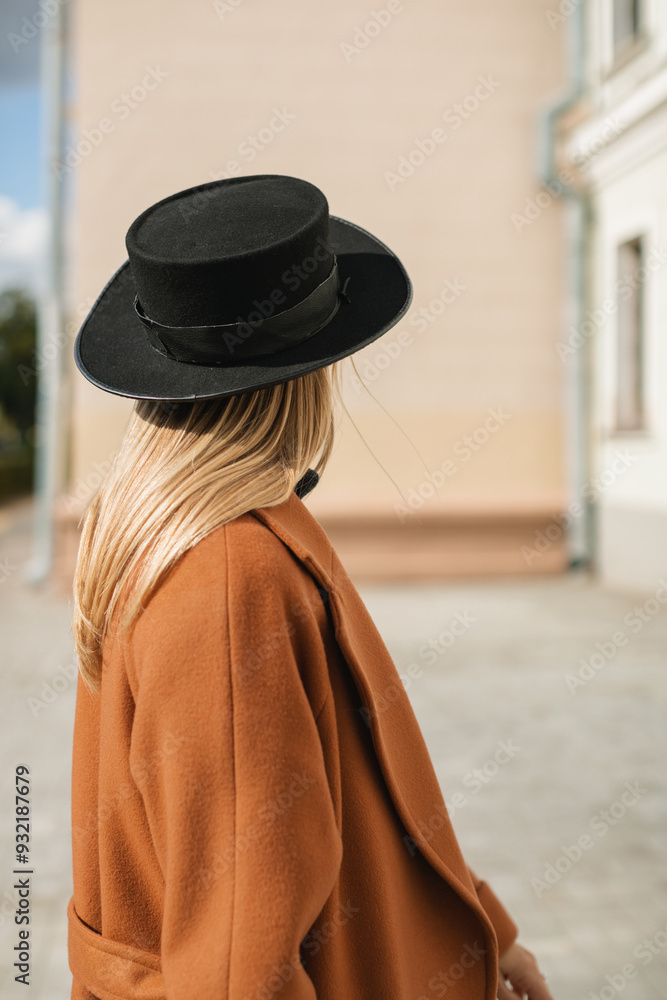 Side view of a stylish woman wearing a hat and winter wool coat on a sunny autumn day Side view of a stylish woman wearing a hat and winter wool coat on a sunny autumn day
