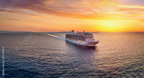 Aerial summer sunset view of a generic cruise ship traveling over the calm ocean as a concept for travel and transport © moofushi