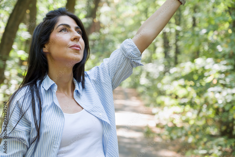 Relaxed woman breathing fresh air in a green summer forest Relaxed woman breathing fresh air in a green summer forest