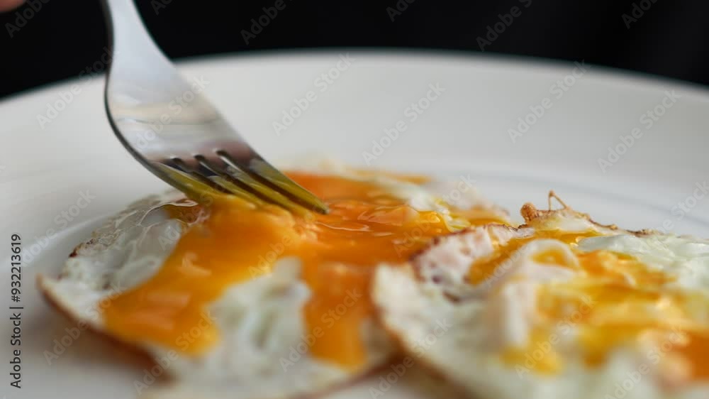 Stir the egg yolk with a fork.
Yolk close-up.
Fried egg and fork Stir the egg yolk with a fork.
Yolk close-up.
Fried egg and fork