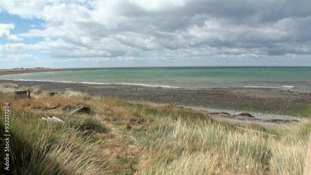 Serene coastal view with waves, shore, grass, and cloudy sky, perfect for tranquil escapes and naturethemed visuals Serene coastal view with waves, shore, grass, and cloudy sky, perfect for tranquil escapes and naturethemed visuals