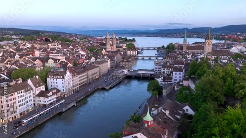 Aerial drone footage of Zurich old town along the Limmat river with Grossmunster cathedral in Switzerland largest city.  photo