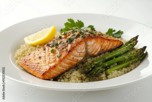 Close-up of a grilled salmon with quinoa and asparagus garnished with fresh herbs on a white plate