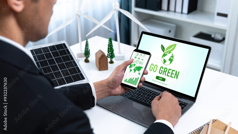 Fototapeta premium Businessman working in office developing plan or project on eco-friendly alternative energy with solar cell technology display on computer screen for greener environment as apart of CSR effort. Gyre