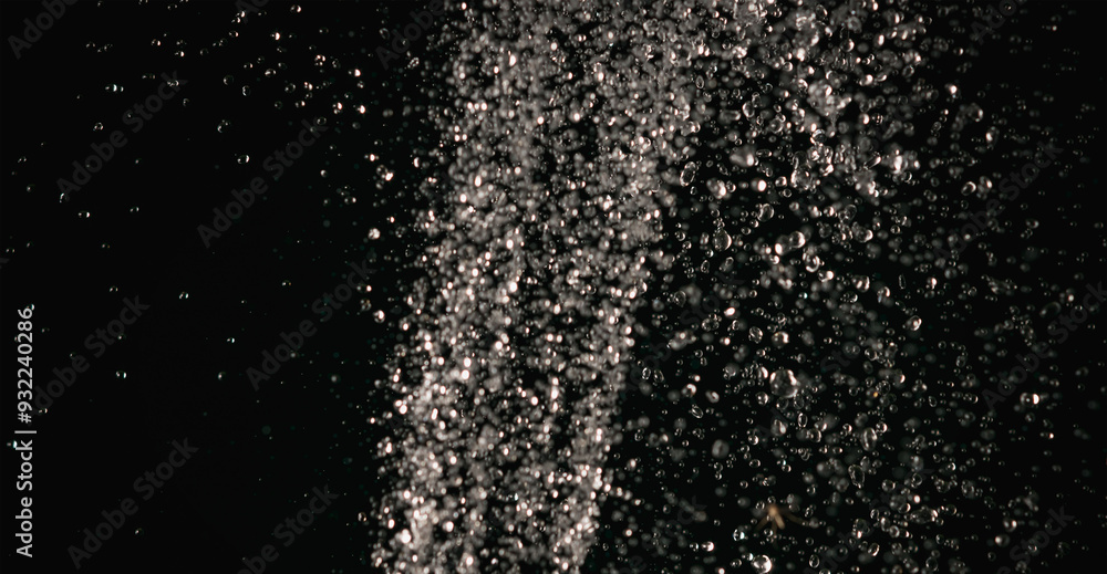 Obraz premium Splashes of water pouring from a hose in the dark