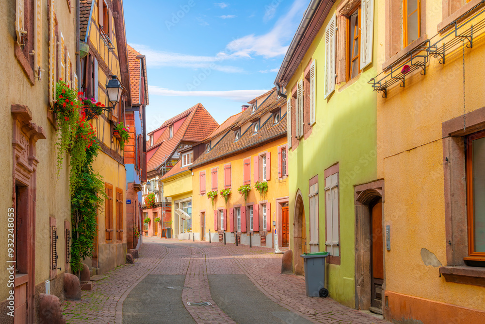 A winding cobblestone street in a residential area of the medieval old town of Ribeauville France, one of the villages of the picturesque Alsace wine region. A winding cobblestone street in a residential area of the medieval old town of Ribeauville France, one of the villages of the picturesque Alsace wine region.