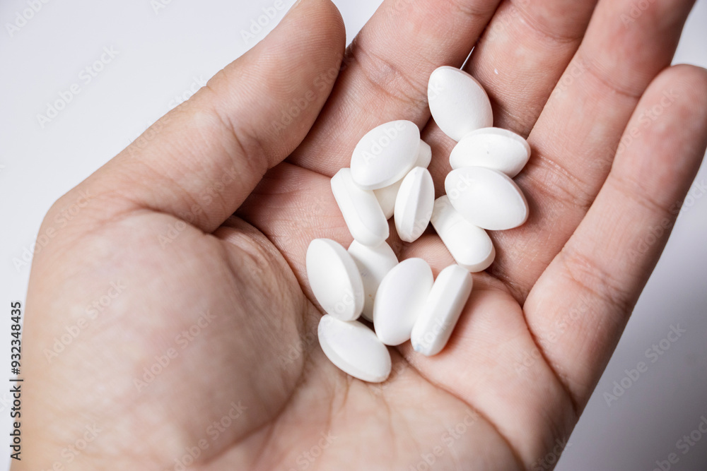 Tablets are in the hand. Yellow capsules, white tablets. Health prevention. Disease Tablets are in the hand. Yellow capsules, white tablets. Health prevention. Disease