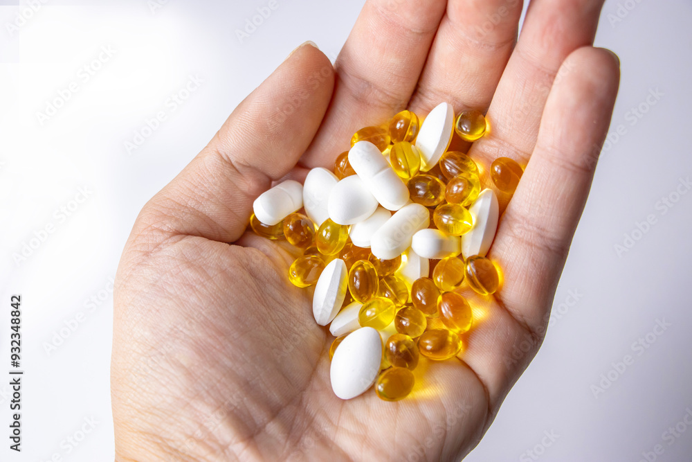 Tablets are in the hand. Yellow capsules, white tablets. Health prevention. Disease Tablets are in the hand. Yellow capsules, white tablets. Health prevention. Disease