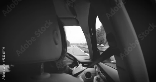 Wallpaper Mural Black and white footage of a woman driving carefully on a highway in a right-hand driving country, evoking a classic and timeless feel on the road Torontodigital.ca