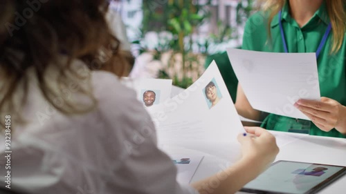 Human resources staff evaluating candidates resume in the selection process, reviewing all applicants after job interview in order to hire the right person. Recruiters seeking personnel. Camera A.