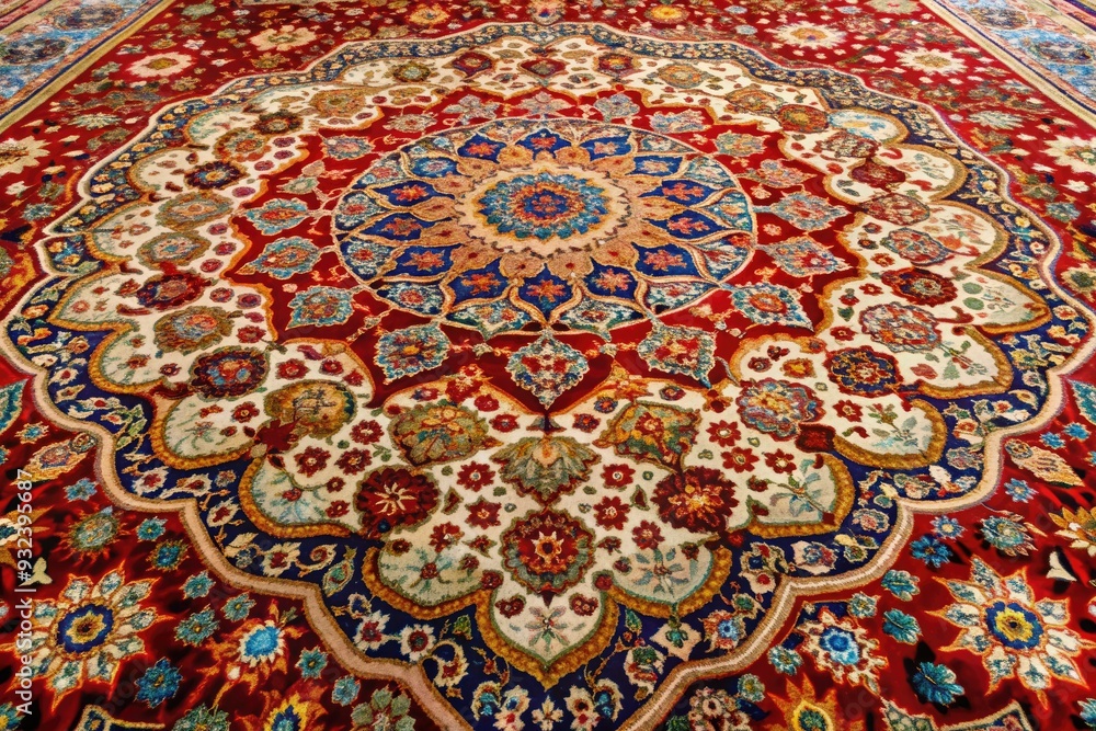 Fototapeta premium Intricately hand-woven and tufted carpet with vibrant colors and ornate patterns, showcasing exceptional craftsmanship and texture, perfect for home decor and interior design inspiration.