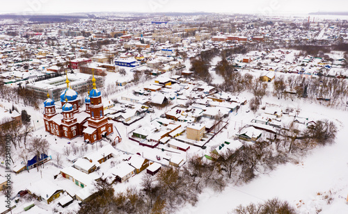 Scenic view from drone of Temple of Intercession of Holy Virgin with Petrovsk cityscape on background in winter, Russia. photo