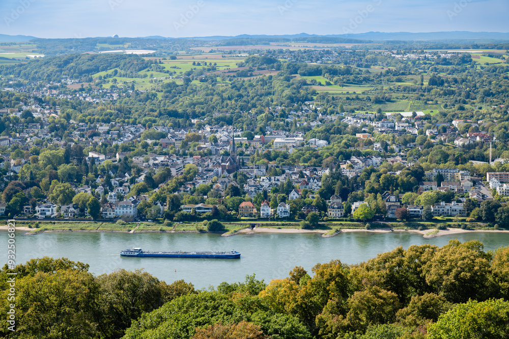 Panoramic view of the Rhine River and the small town surrounding it, with green hills and countryside landscape stretching into the distance under a sunny sky. Panoramic view of the Rhine River and the small town surrounding it, with green hills and countryside landscape stretching into the distance under a sunny sky.
