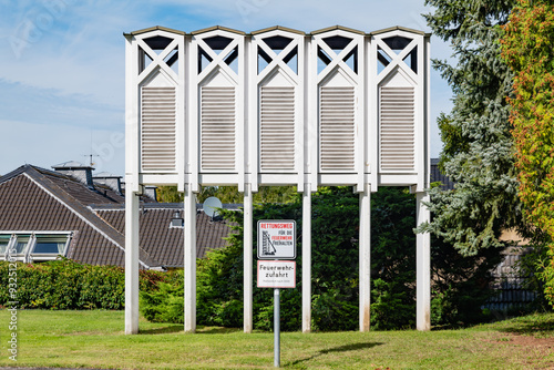 Modern ventilation structure with louvers located near Klosterruine Heisterbach. A sign beneath it indicates 