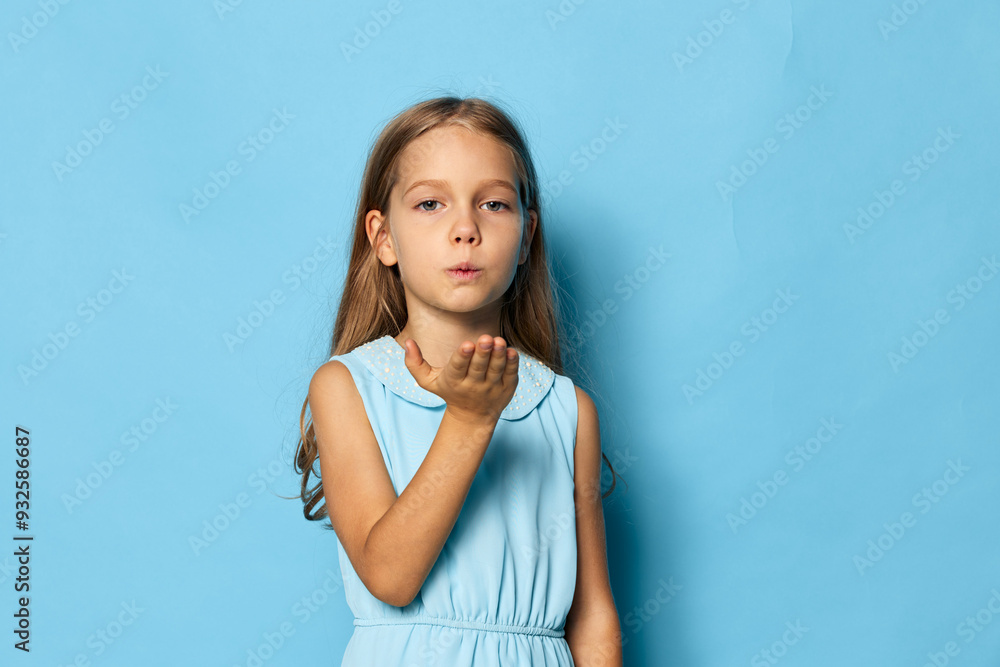 Get a stock photo of a girl blowing a kiss on a blue background for your project Get a stock photo of a girl blowing a kiss on a blue background for your project