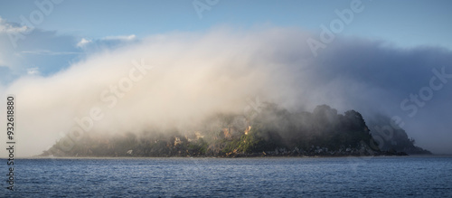 a cloud of fog and mist over lion island on nsw central coast australia