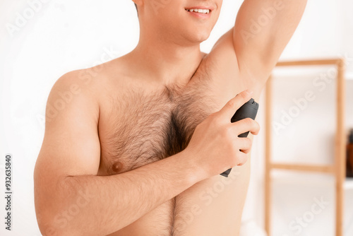 Young man applying deodoran...