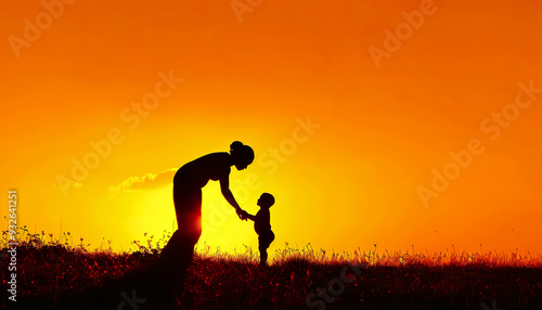 Silhouette of a mother and child holding hands at sunset