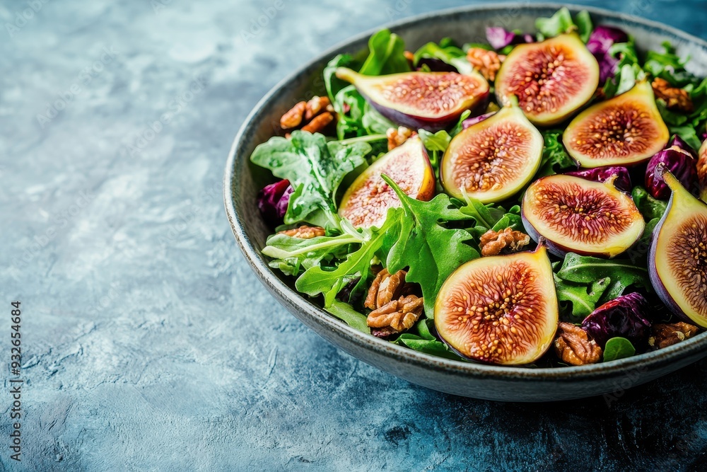 Vegan paleo fall salad with figs arugula fruits nuts and honey on blue surface Vegan paleo fall salad with figs arugula fruits nuts and honey on blue surface