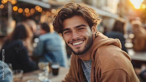 A young man smiles warmly o...